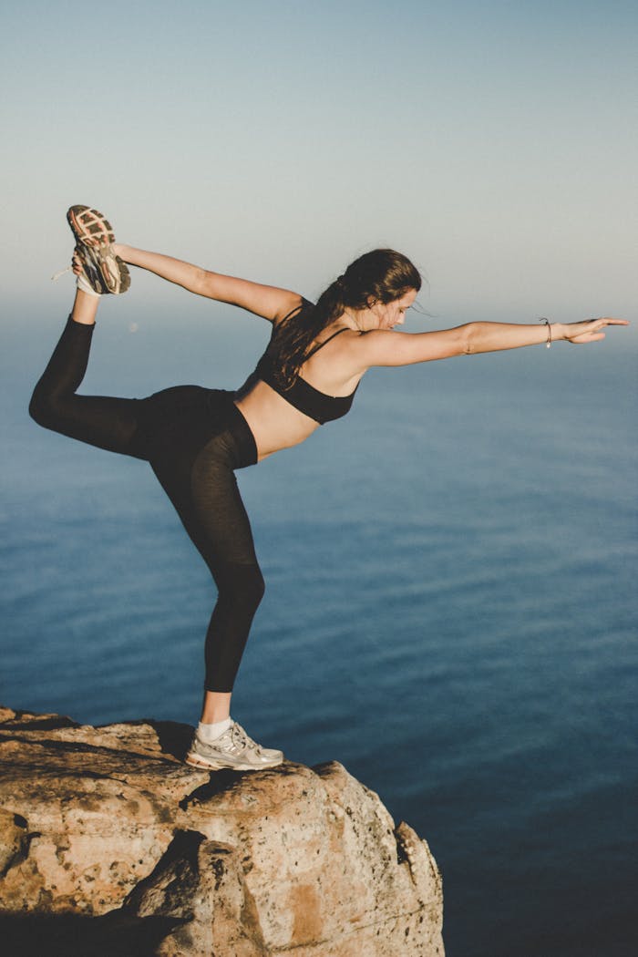 Woman Wearing Black Bra and Pants on Top of the Mountain Near Lake